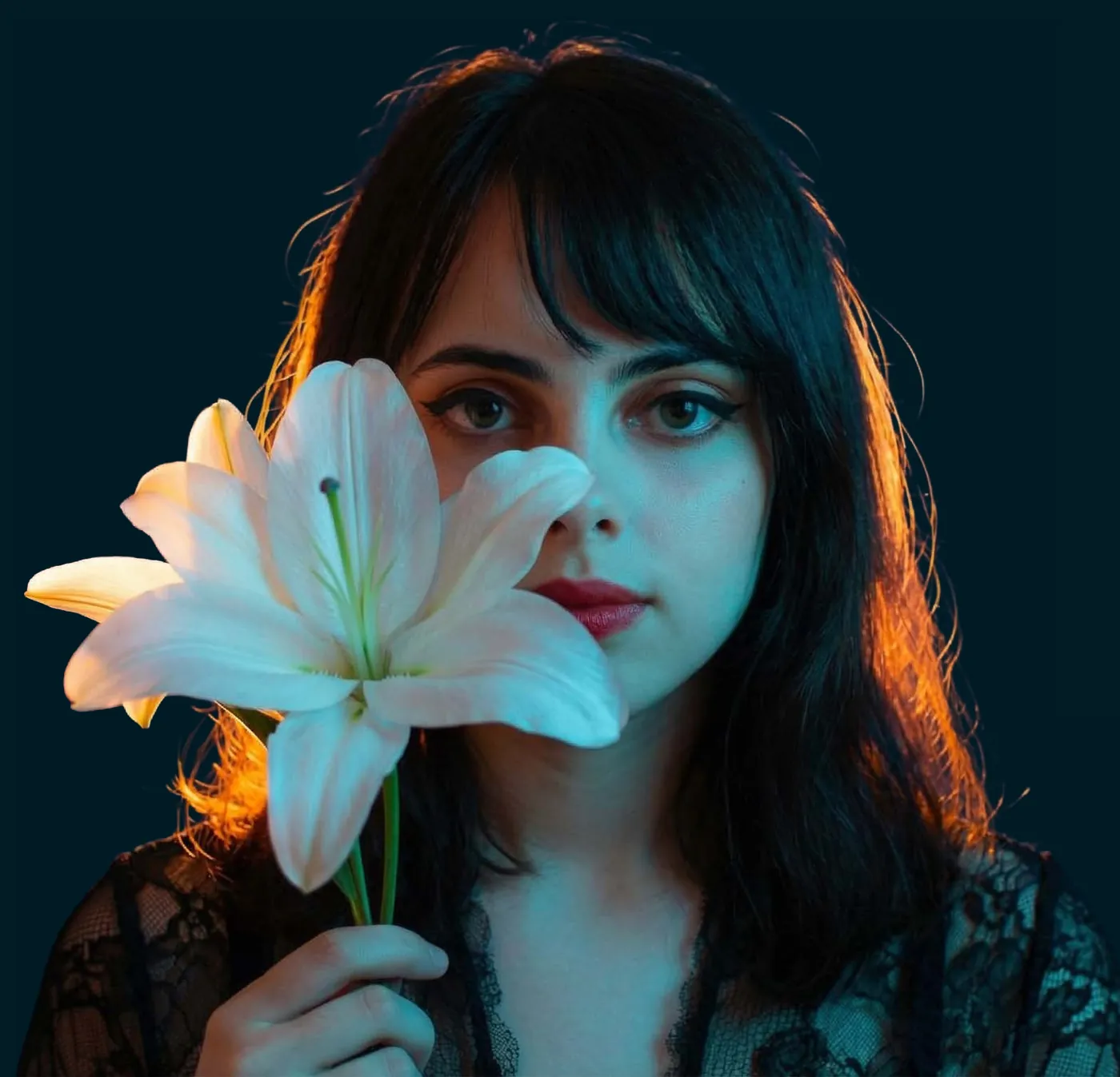 Lily holding a white lily in blue light